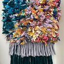 A multi-coloured weaving comprised of hundreds of rya knots and a double fringe that is grey and forest green. . Een project van Weven van Camille Haggar - 13.01.2021