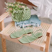 Sandalias verdes minimalistas sobre silla