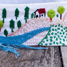Paisaje bordado sobre cuello