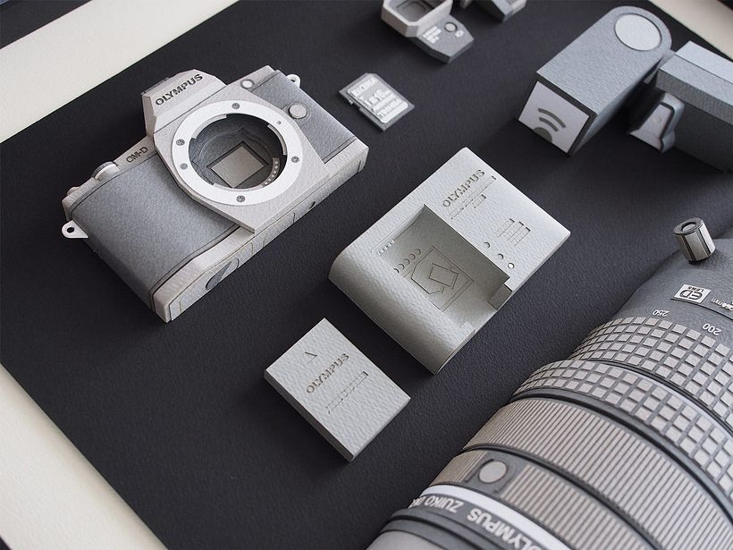 Papel, cúter y pegamento para construir una cámara fotográfica 3