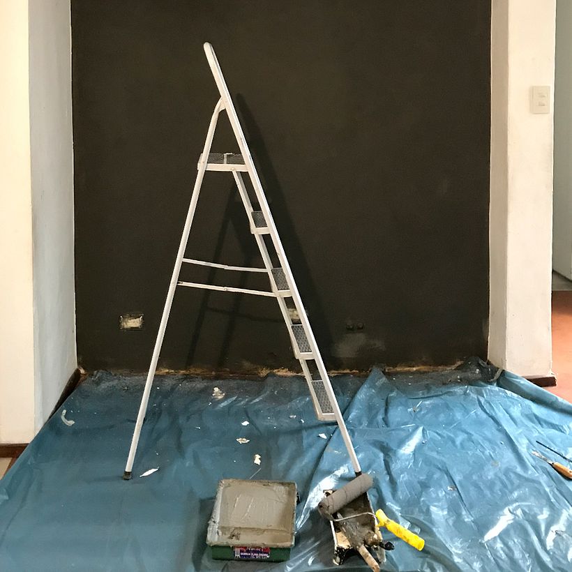 Primera mano de pintura. Elegí revestimiento de pared gris oscuro texturado porque quería que los marcos destacaran.