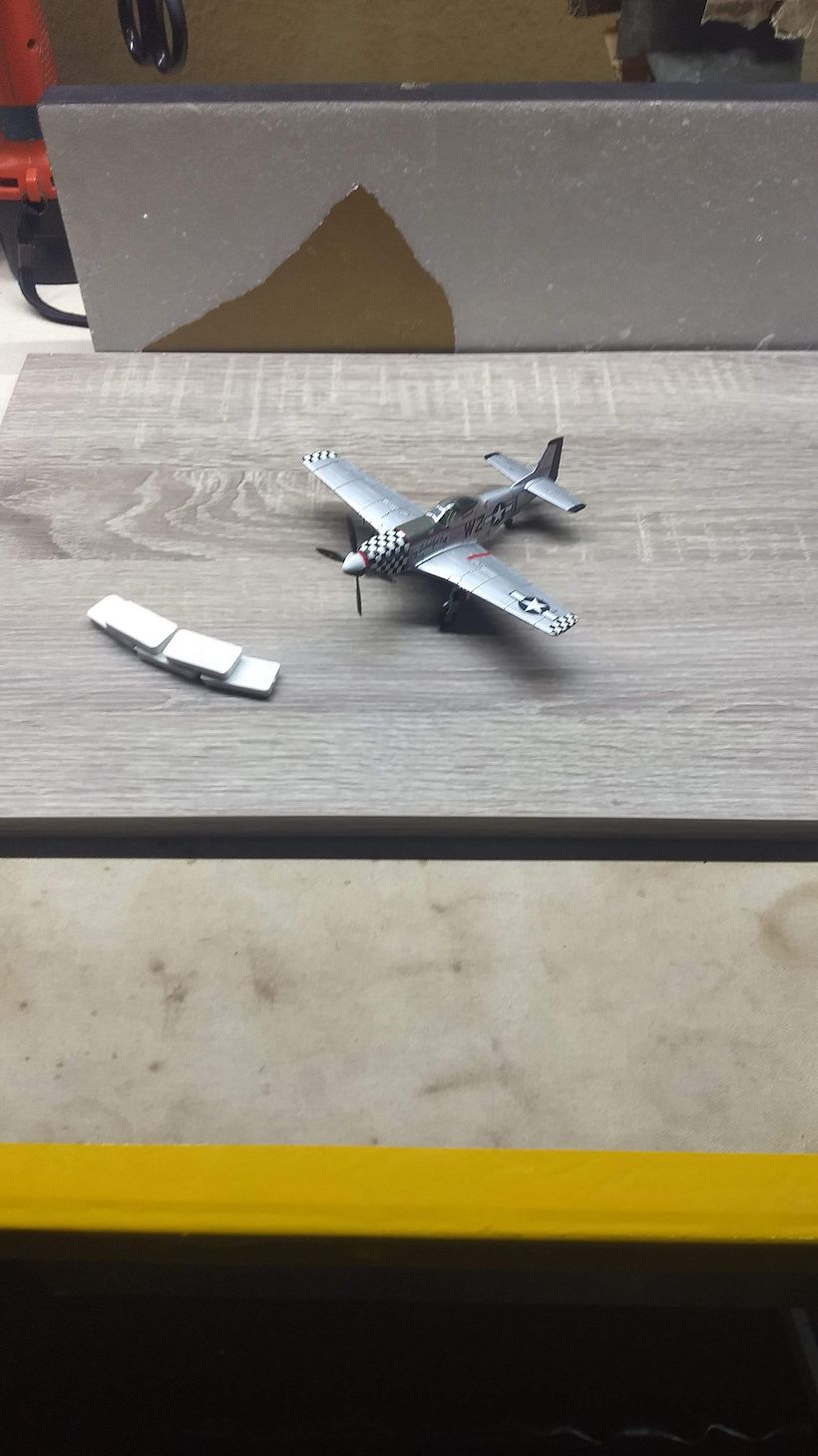 es un pequeño avion a escala de la guerra una pieza de una autopista de carreras de juguete una tabla unas piezas de plastico