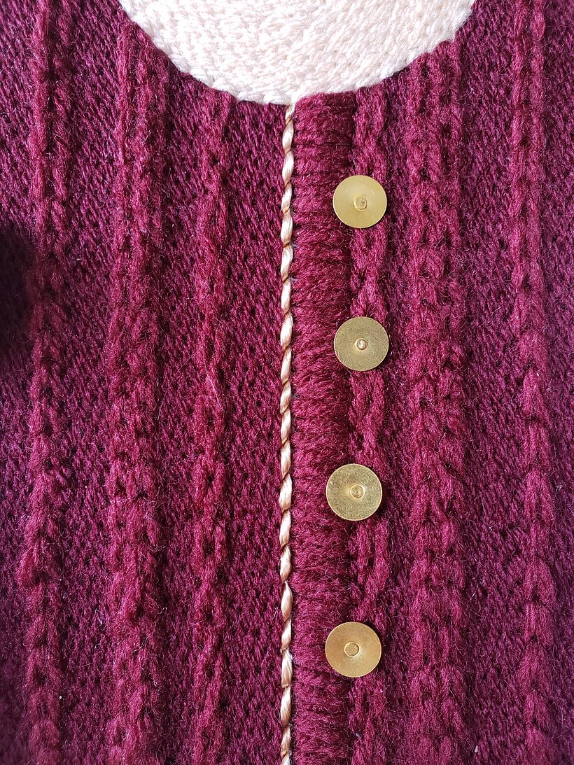 Detalle de cadena con lana gruesa imitando sweater. Tachas como botones.