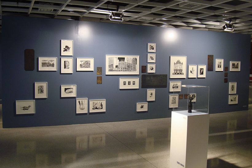 Parede com as matrizes e xilogravuras emolduradas.