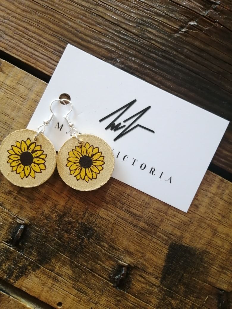 Aretes con girasoles en círculos de madera.