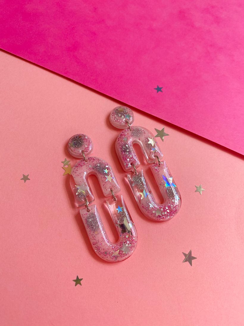 Mixed glitter star earring with pink and clear resin.