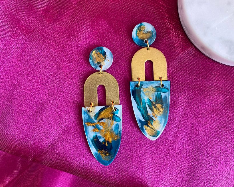 Brass arch earrings with brush strokes and gold mica powder.