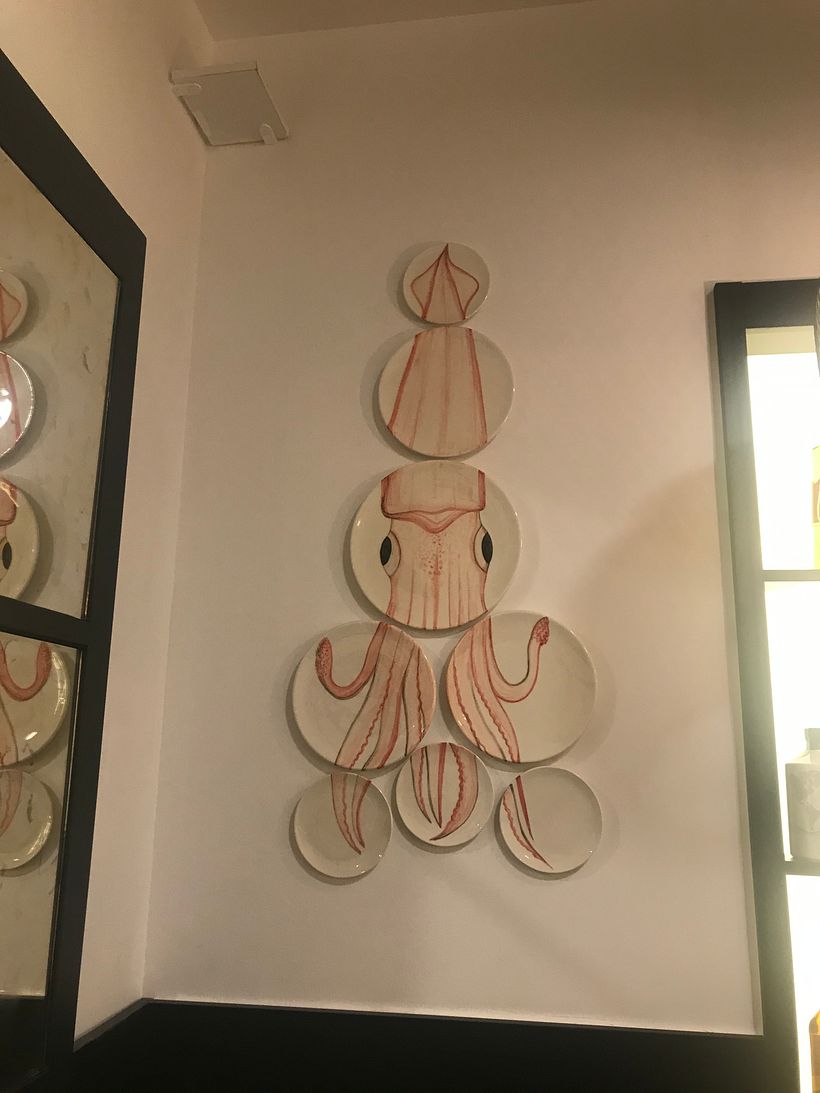 Calamar pintado a mano sobre varios platos realizados a medida para la pared del salón del restaurante