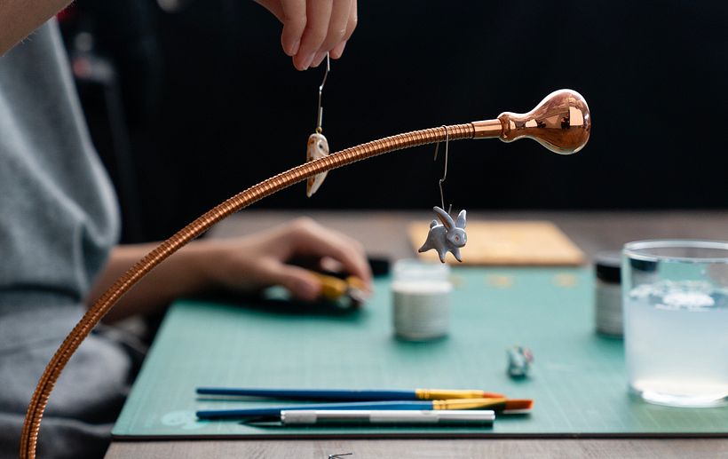 Marisa utiliza una lámpara de mesa con clips para colgar las piezas.