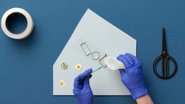 Despeje uma fina camada de resina no interior da parte do central do bisel e espalhe até as bordas com o palito de silicone