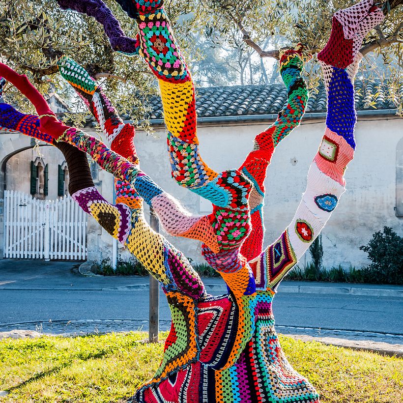 A yarn-bombed tree, Adobe Stock.