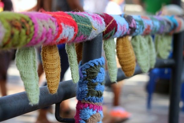 O 'yarn bombing' está presente em muitas cidades: em árvores, parques infantis e mobiliários urbanos. Adobe Stock