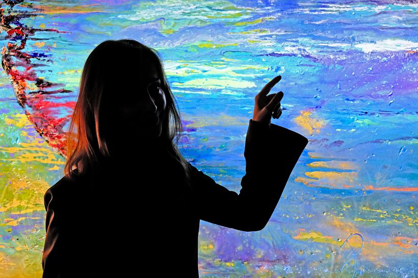Pamen Almagro silhouette in front of her painting