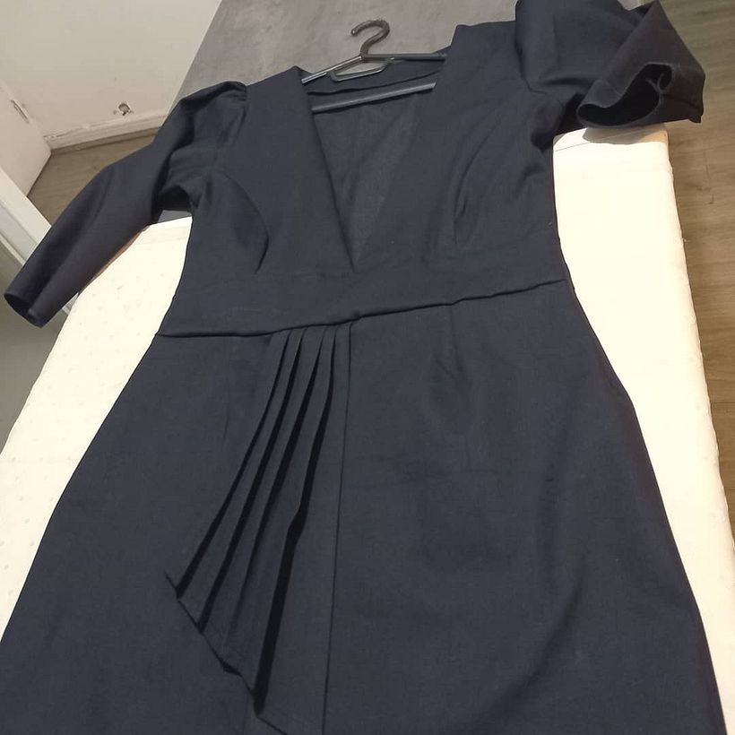 Vestido corto con pliegues que disimulan a ertura en pierna y cuello escotado en v, manga embombada  