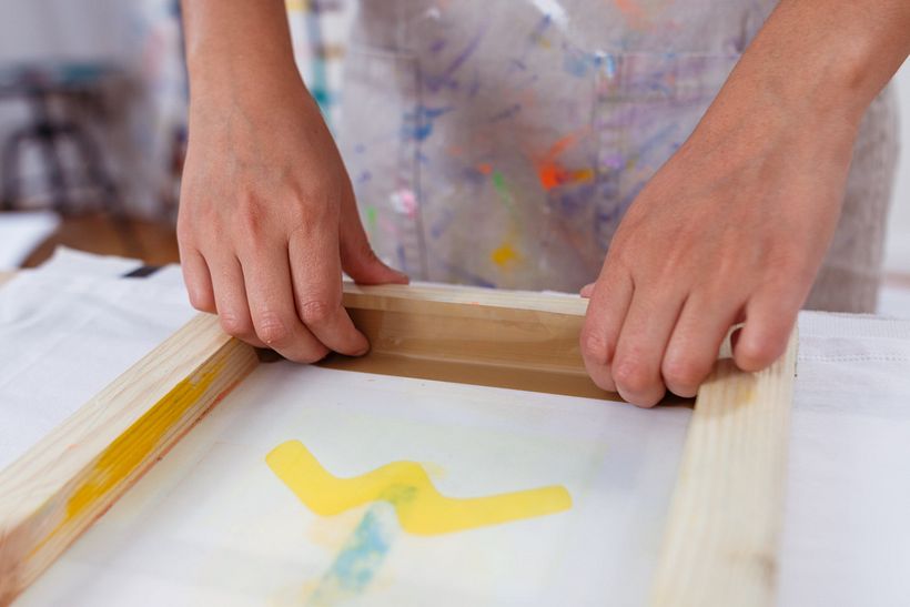 The creators of Festela in the process of screen printing a design.