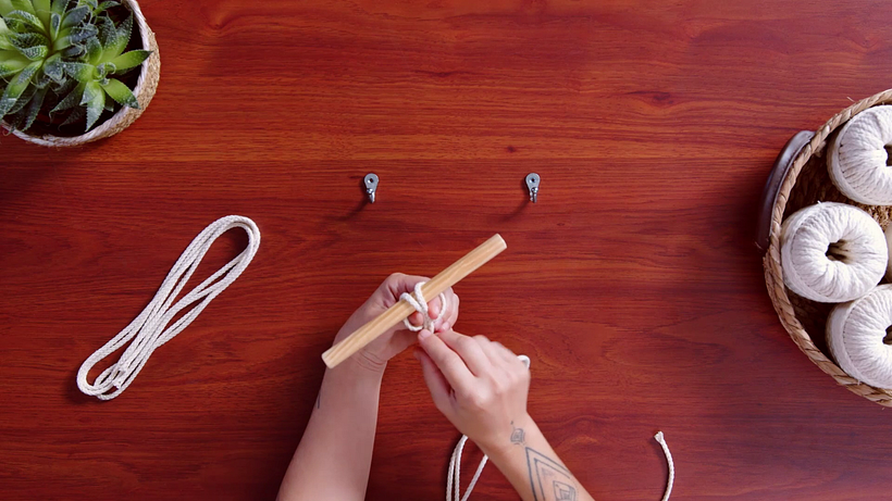 Tie a lark’s head knot to attach your cord to the wood.