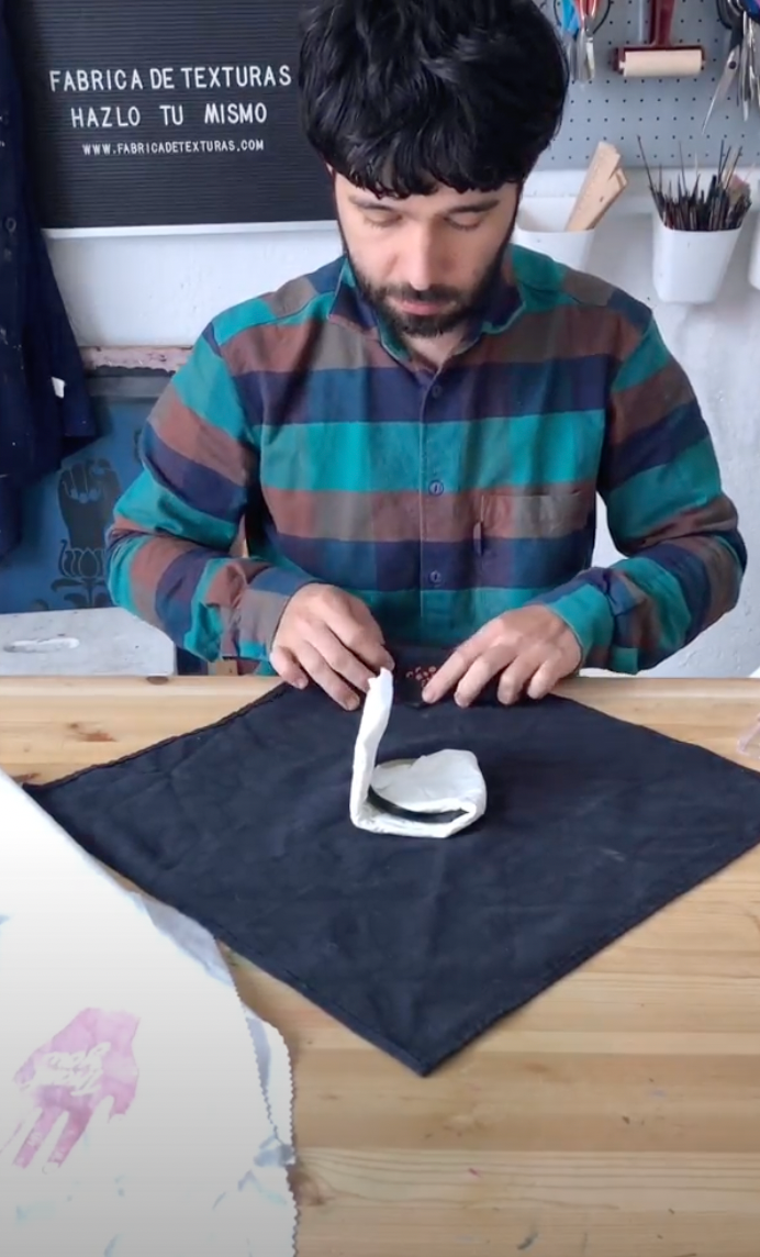 Se dobla la servilleta de tela por dos lados. 