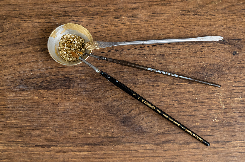 Diferentes pinceles con polvo de oro.
