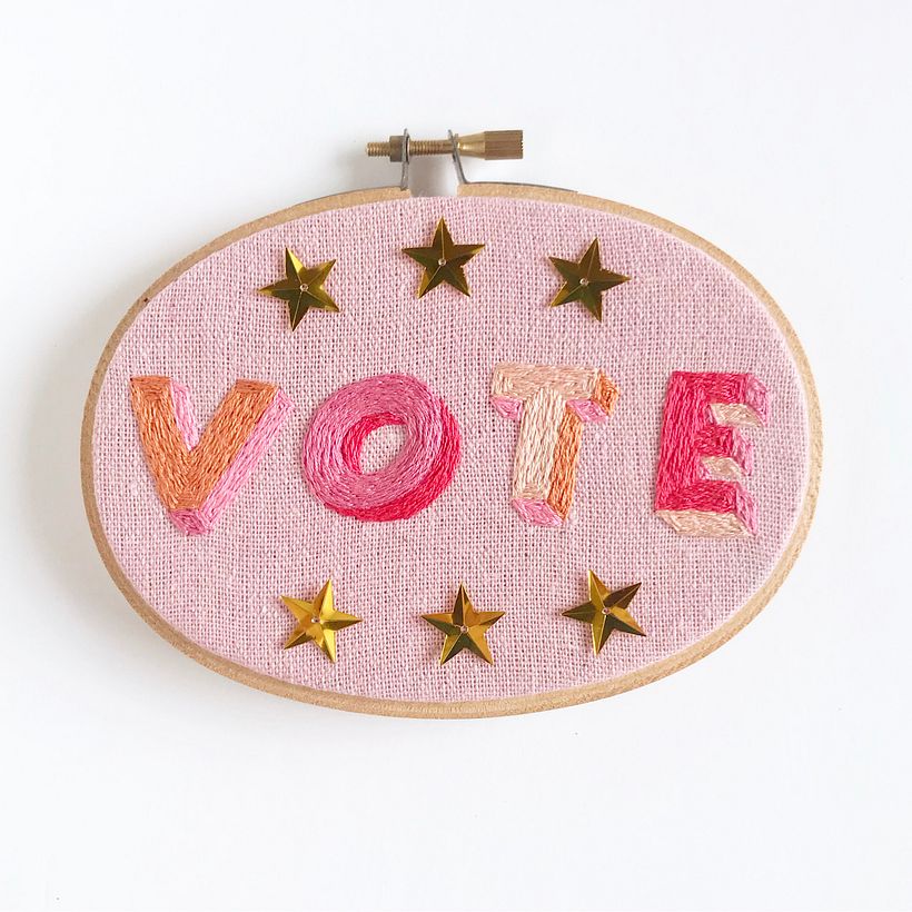 "VOTE" hand embroidery in oval hoop. Cotton and sequins on linen. Finished size 3" x 5".