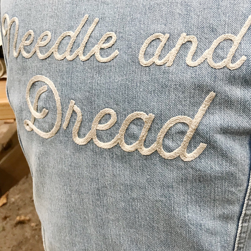 Hand lettered and stitched on denim.