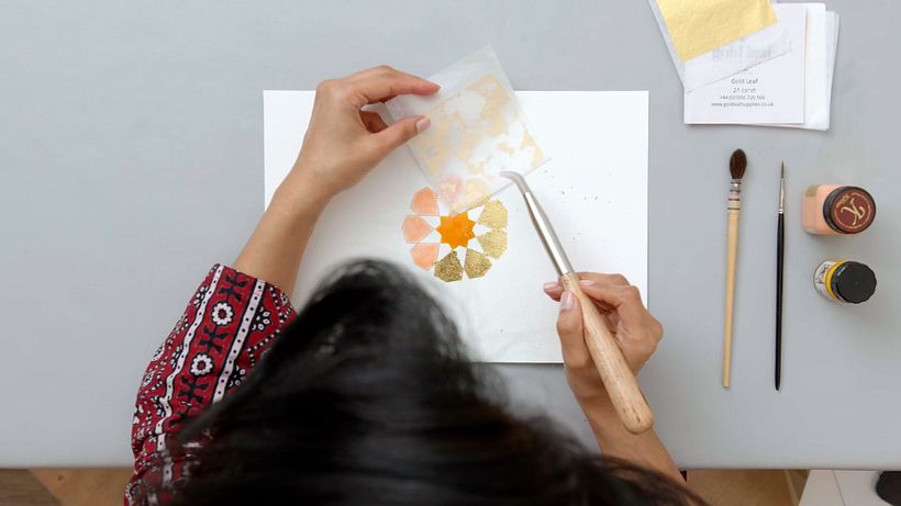 Apply your gold leaf onto the Miniatum size and rub your burnisher over the back of the sheet