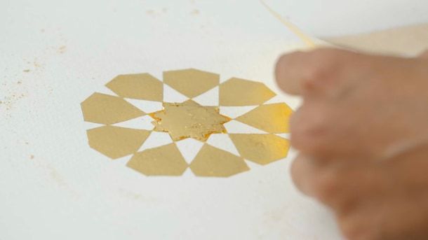 Assopre a superfície em relevo para deixar as extremidades novamente pegajosas e, em seguida, aplique outra camada de ouro