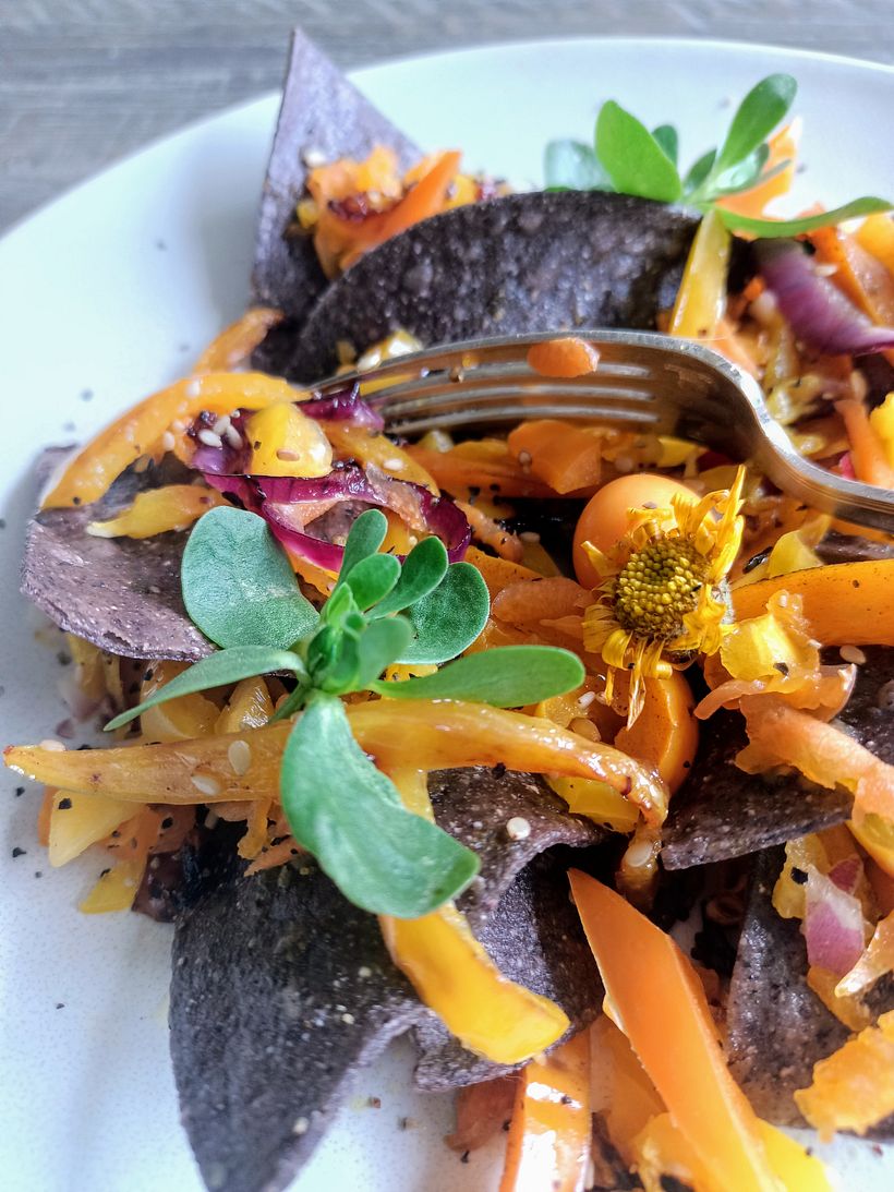 Ensalada de pimientos amarillos sobre totopos de maíz azul