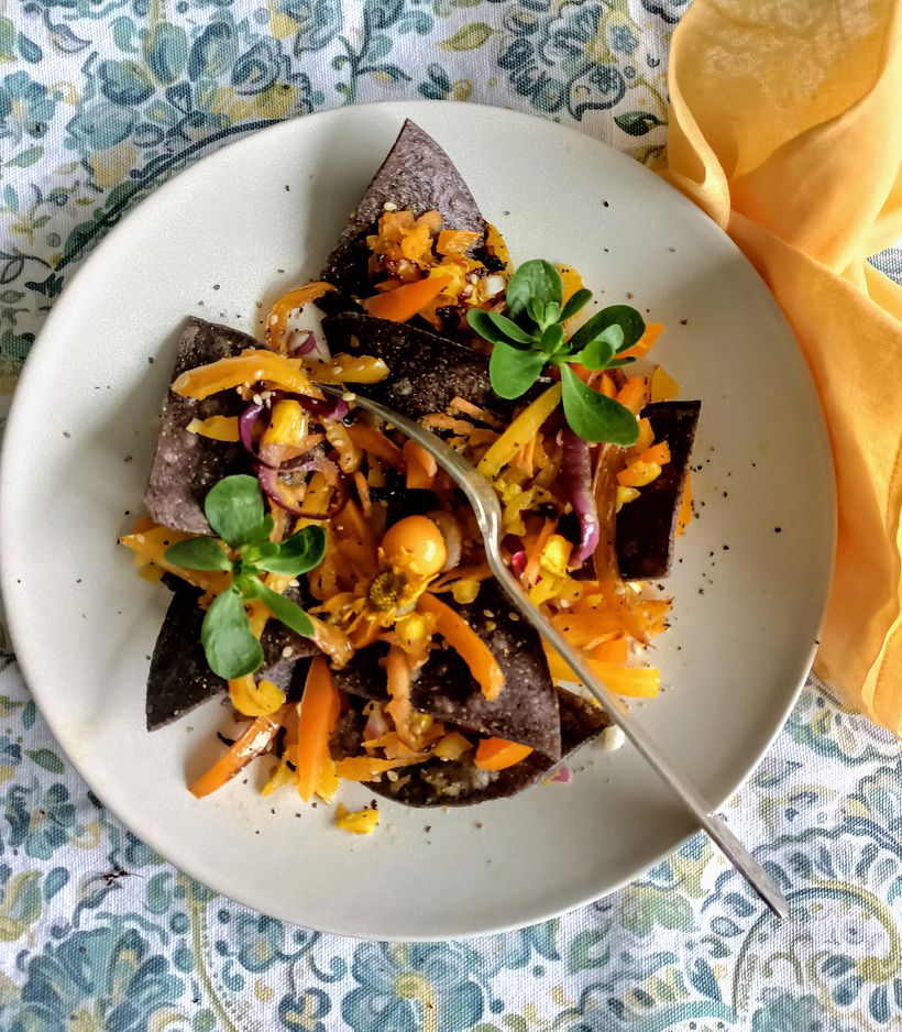 Ensalada de pimientos amarillos sobre totopos de maíz azul