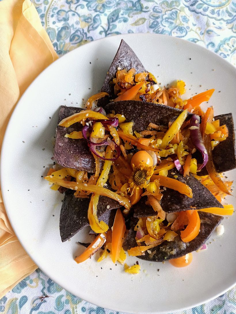Ensalada de pimientos amarillos sobre totopos de maíz azul