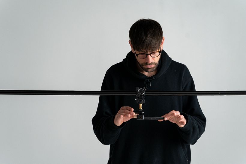 El adaptador es la pequeña pieza dorada de la foto, hecha para conectar diferentes tipos de trípode o soporte.