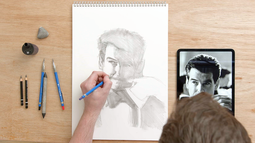  Sam Brisley usa un lápiz para recrear el rostro de Pierce Brosnan.
