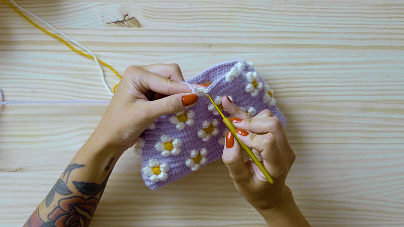Pull the purple yarn through the last stitch, remove the hook, and insert it into the first white stitch
