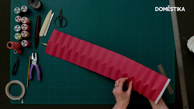 Gently push each section into a peaked V-shape with one hand on either side of the paper