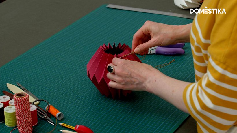 Thread the string through the holes using a needle and pull the ends together