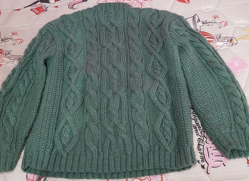 Prenda con dibujos en trenzasa con bordes en pundo arroz doble