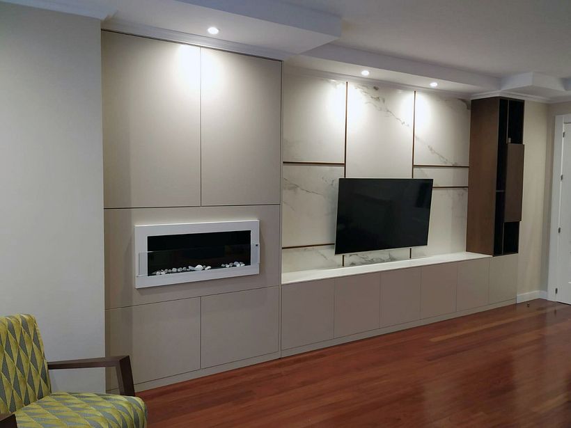 Mueble para la tv con chimenea empotrada, armarios y pared revestida en cerámico