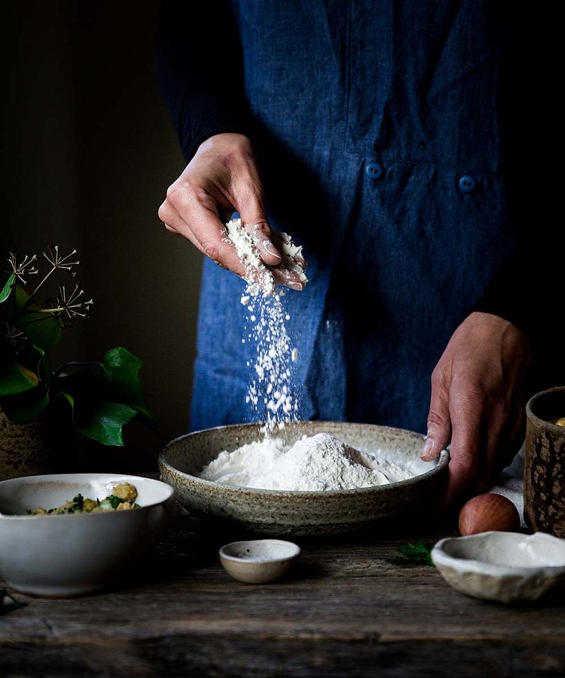 Every prop and background element is darker than the flour, allowing it to pop with high contrast.