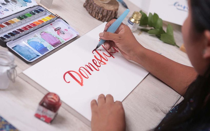 Lucia illustrates a familiar word using a brush pen...