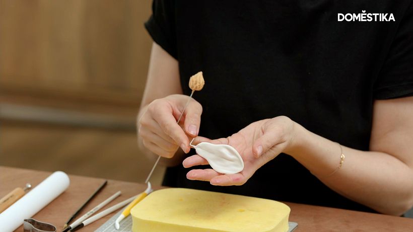 She bends the wire of her petal to a 90 degree angle before attaching it to her stem