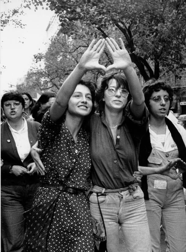 Two women giving a feminist gesture, by Pilar Aymerich.