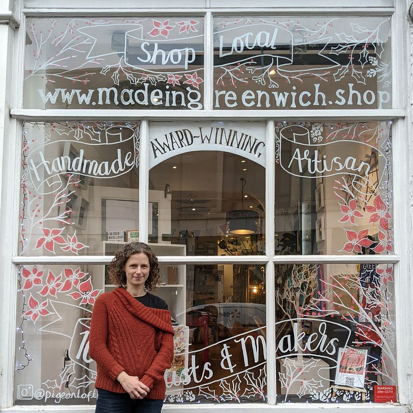 Artist, Ellen Strachan outside the completed Made in Greenwich Christmas window