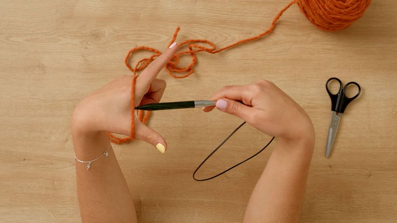 Forma una V con los dedos y el hilo.