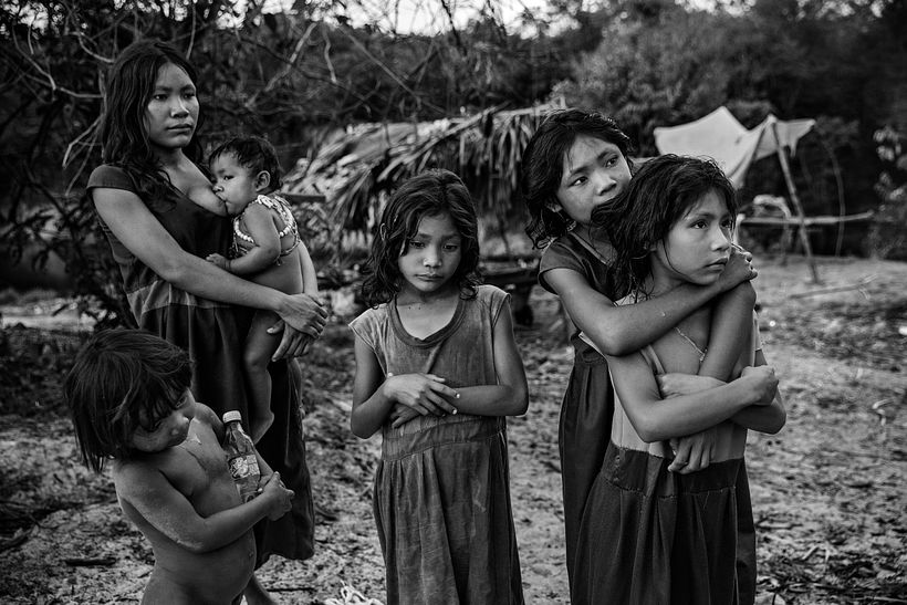 Mujeres y niños de la comunidad Pirahã, en el río Maici, observando a conductores. Lalo de Almeida para Folha de São Paulo.