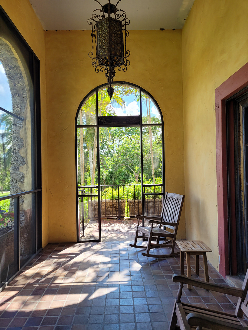 (Miami, 2021) A large arched window casts light onto the adjacent yellow walls, opening the house to the nearby courtyard.