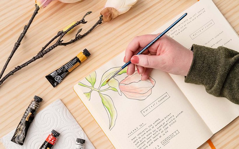 Annie adds floral illustrations based on reference to her journal.