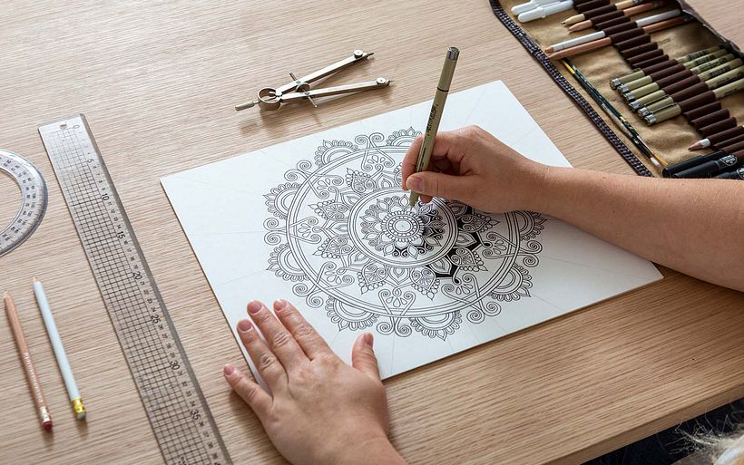 Lizzie adds depth to her mandala illustration.