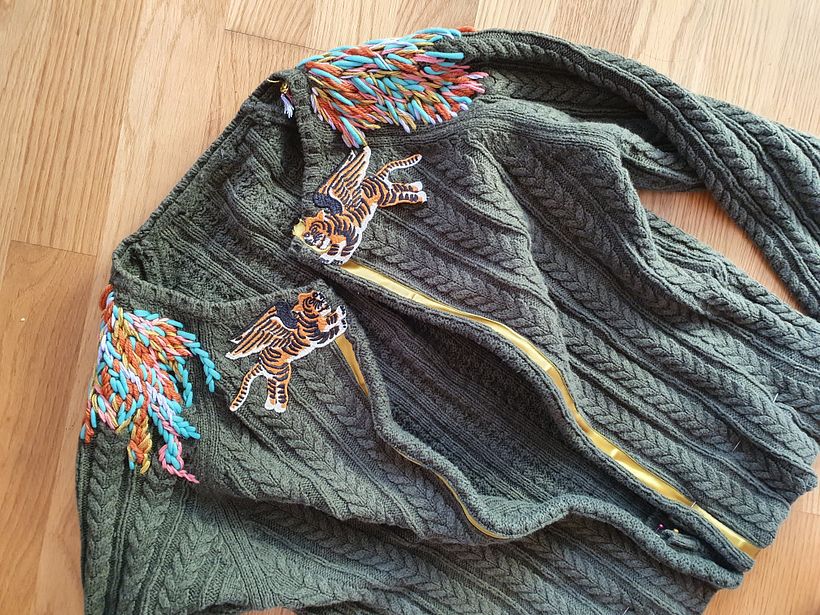 I used my husband's old sweater, chartreuse satin bias tape, appliqués of winged tigers I found on Etsy, and various yarns.