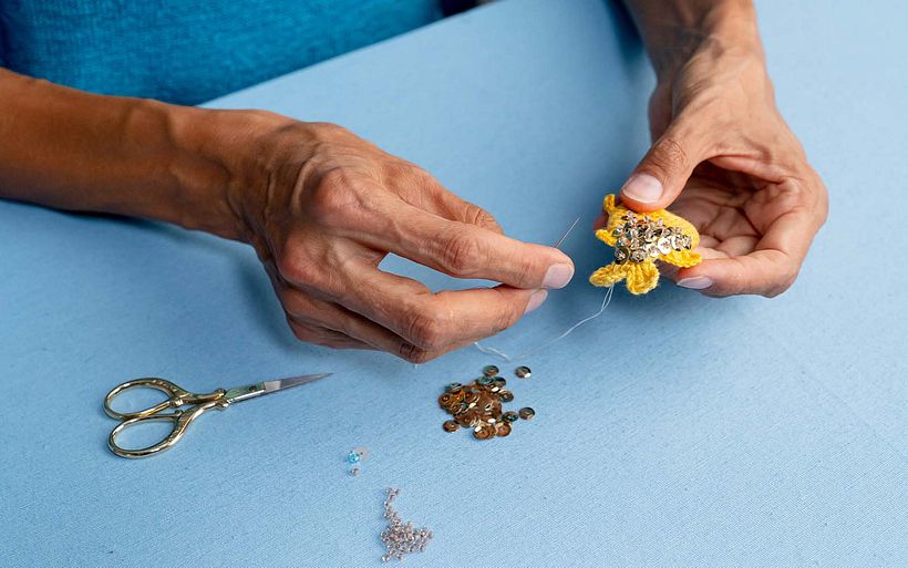 The final touches for the embellished fish crochet piece.