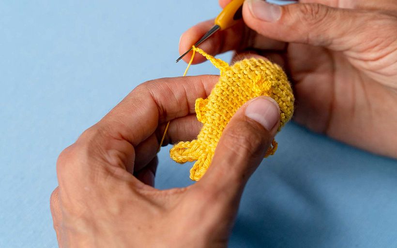 Marianne häkelt den Körper des Fischmusters, bereit für die Verzierung.