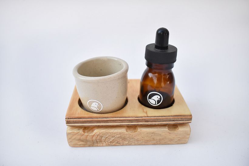 Tiene un vaso artesanal cerámico y un gotero de vidrio para el agua.